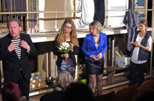 2. Akt: Dem Regisseur (li) wird warm. Gerade hat er Blumen verschenkt und seine zweite Flamme hat es mitgekriegt. © OVTP / gp